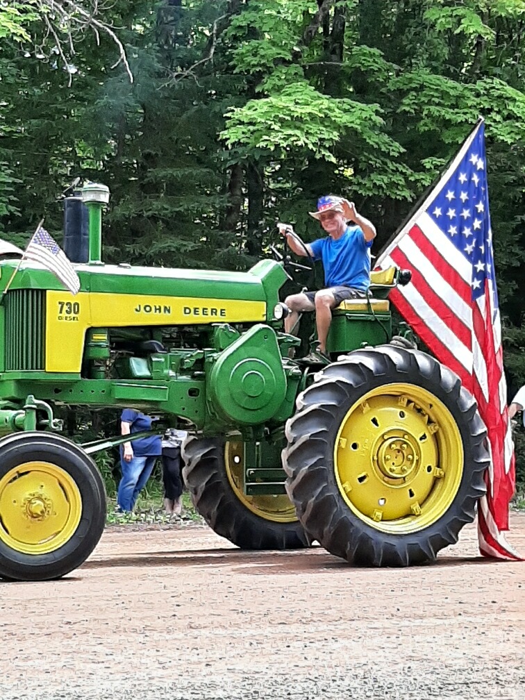 Kent Staab waving from a John Deere 730 tractor at a parade